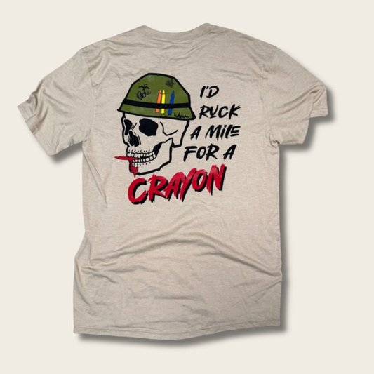 A light heather gray t-shirt shown from the back, featuring a graphic of a skull wearing a green military-style helmet with colored pencils and a red crayon in its teeth, next to the text 'I'D RUCK A MILE FOR A CRAYON' in black and red.