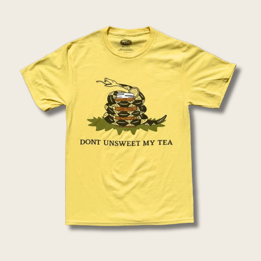A yellow short-sleeve t-shirt with a coiled rattlesnake graphic and the text 'DONT UNSWEET MY TEA' printed on the front, displayed against a light beige background.