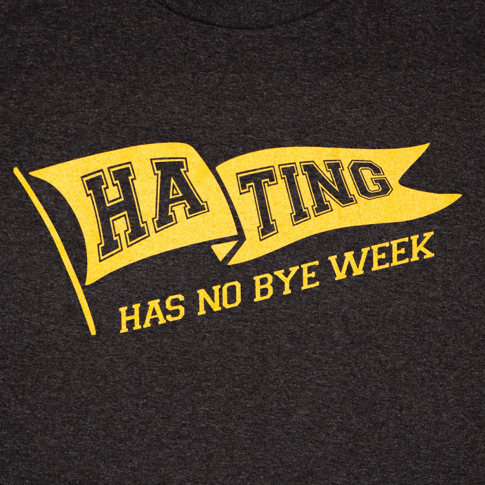 Black t-shirt with yellow and black text design on a dark background