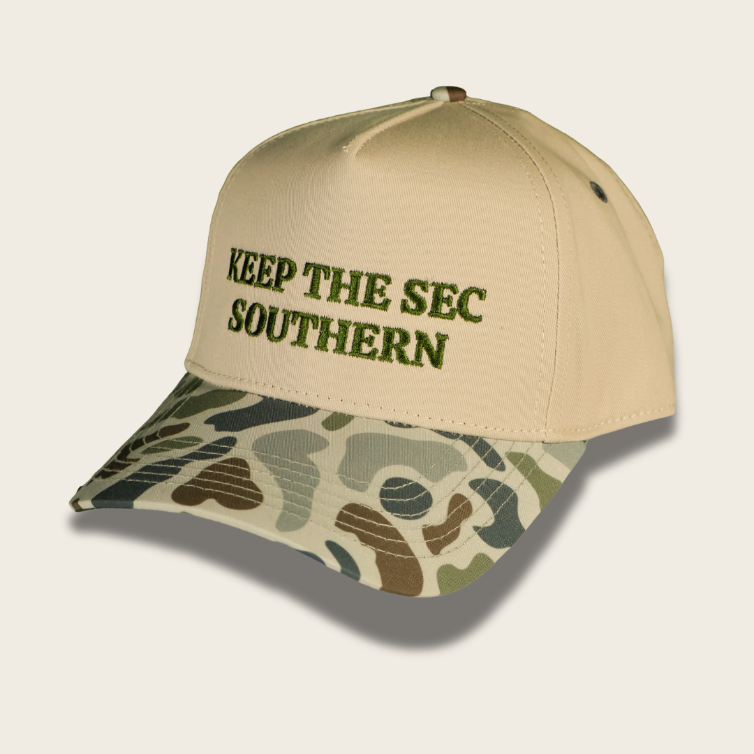 A baseball cap with a beige crown and a camouflage-patterned brim, featuring the embroidered text 'KEEP THE SEC SOUTHERN' in olive green on the front.