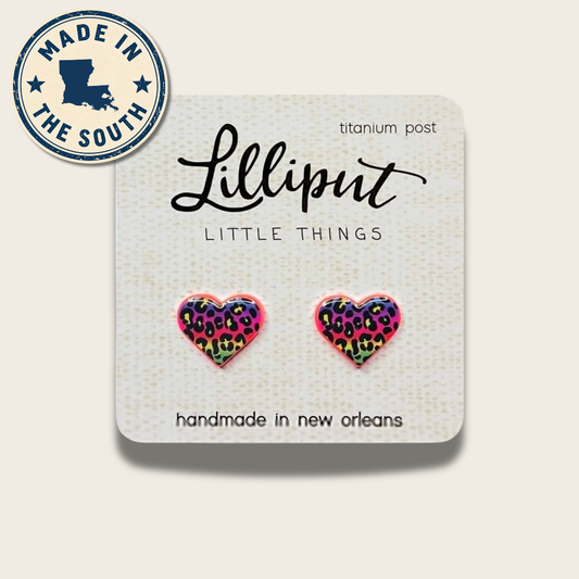 A pair of heart-shaped stud earrings with a colorful leopard print pattern on a white display card. The card has the brand name 'Lilliput' and 'LITTLE THINGS' printed on it, along with a circular 'MADE IN THE SOUTH' badge in the top left corner.